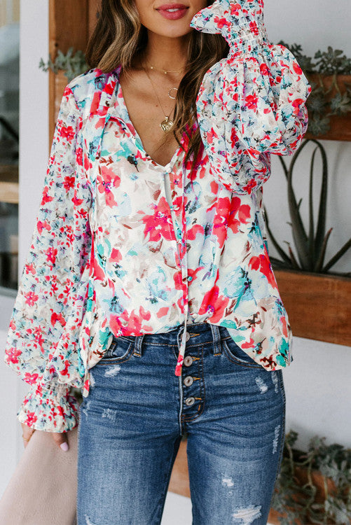 Beautiful floral print in reds, pinks, blues and aqua. Blouse is button up with ties at ruffled neckline. Long billowy sleeves with smocked cuffs. Buttons are fabric covered and are loop fastening. Excellent quality and well designed blouse! 