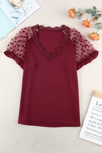 Burgundy polka dot lace short sleeve top. Lace V-neck with a soft silky like bodice and ruffled short sleeves that gives it an elegant look. Nice relaxed roomy fit top. Polyester blend fabric with very mild stretch. Sleeve ruffles are not elastic. 