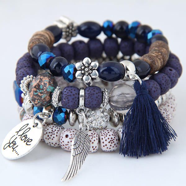 Navy, silver and white beads, make up this fashionable 4-piece bracelet set. Stretch elastic bands with beautiful beads of navy, silver, browns and white. Also adorned with metal floral, tassels and metal tags. 