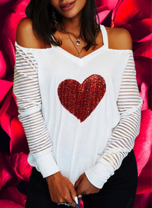 Lightweight knit long-sleeved top with sequined red heart design on front. V-neck cold shoulder sleeves. Stretchy elastic around shoulders for better fit. Banded hem is stretchy. Is very roomy top! 