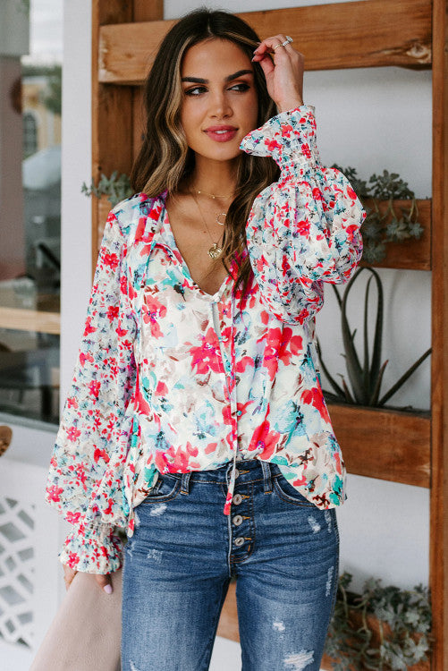 Beautiful floral print in reds, pinks, blues and aqua. Blouse is button up with ties at ruffled neckline. Long billowy sleeves with smocked cuffs. Buttons are fabric covered and are loop fastening. Excellent quality and well designed blouse! 