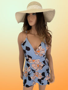 Periwinkle blue romper with big beautiful white flowers is made of lightweight breezy textured crepe material. Has adjustable shoulder straps with a V-neck and fitted lined bodice. It has a high waist bottom with wrap around design front. Brighten up your summer wardrobe with this fun romper. No stretch fabric. 
