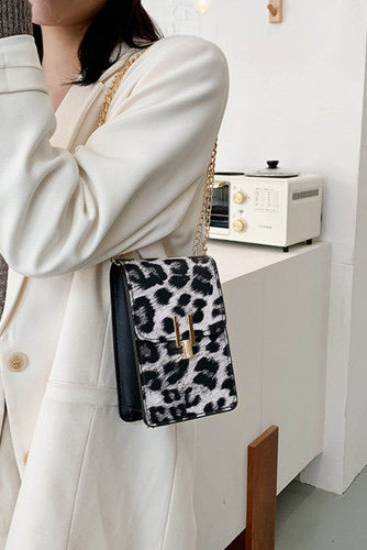 Black leopard print crossbody purse. Trendy and classy purse perfect to hold the necessities when going out or to a fancy occasion. Beautiful gold accent magnetic closure with long gold chain strap. Purse is made of PVC. 