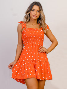 Orange polka dot smocked ruffled sun dress with shoulder tie straps. Light and airy fabric, perfect for hot sunny days. 