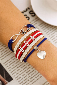 USA patriotic bracelet made with 5 bands connected with silver clasps to make a one piece bracelet. Bands contain braided and straight strings or ribbon adorned with metal attachments like USA lettering and a dangling silver heart. Very nice quality bracelet.  Clasp chain can adjust for sizing. 