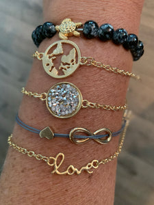 Bracelet set includes one black beaded with gold turtle stretch band, 3 gold chain with metal and jewel adornments, and one gray string with gold metal hearts, all with metal clasp closure. These can fit small to large wrists. 