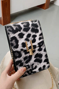Black leopard print crossbody purse. Trendy and classy purse perfect to hold the necessities when going out or to a fancy occasion. Beautiful gold accent magnetic closure with long gold chain strap. Purse is made of PVC. 