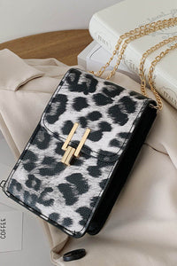 Black leopard print crossbody purse. Trendy and classy purse perfect to hold the necessities when going out or to a fancy occasion. Beautiful gold accent magnetic closure with long gold chain strap. Purse is made of PVC. 